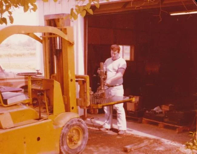 Stecker employee next to forklift in 1973